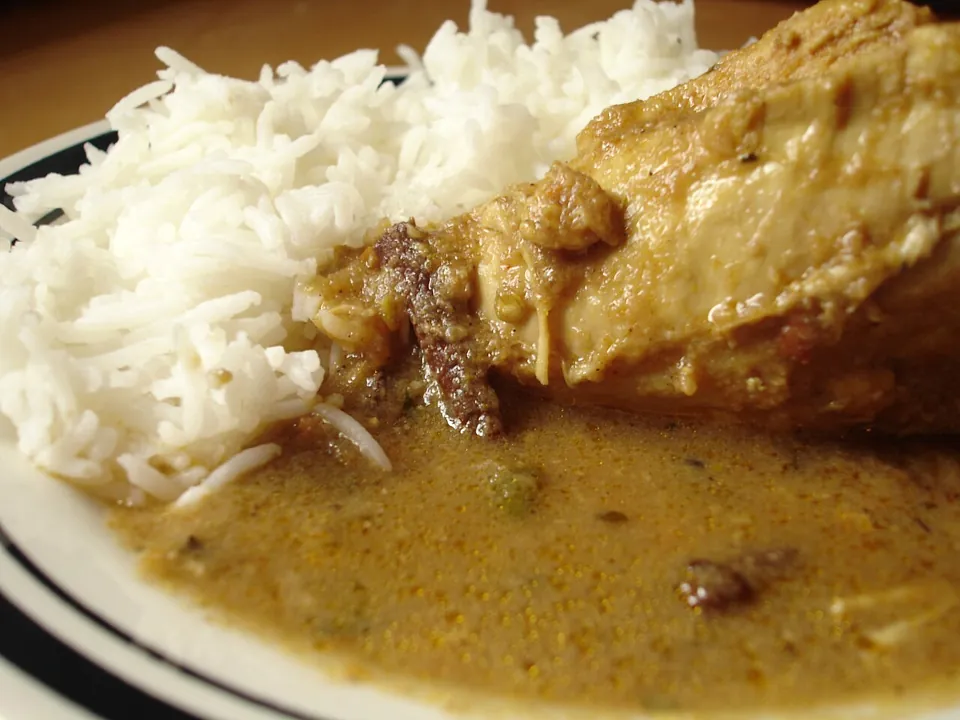 英国式カレー（カレー粉・Anglo-Indian）の実写写真（カレー粉の黄褐色・小麦系のとろみのあるソースに鶏肉、白飯を同皿に添えた家庭風カレー＝英国式(カレー粉)カレーの視覚的代表。撮影は家庭料理『quick and easy chicken curry』で英国と明示された文脈ではない点、寄りのクロップで皿全体は写らない点は承認判断の留保材料。インド現地カレーやタイ/日本の洋食カレーではない中立な完成皿として選定。）